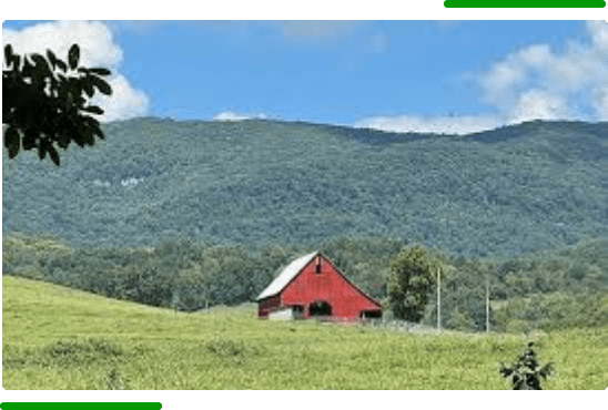 A red barn sitting in the middle of a green field.